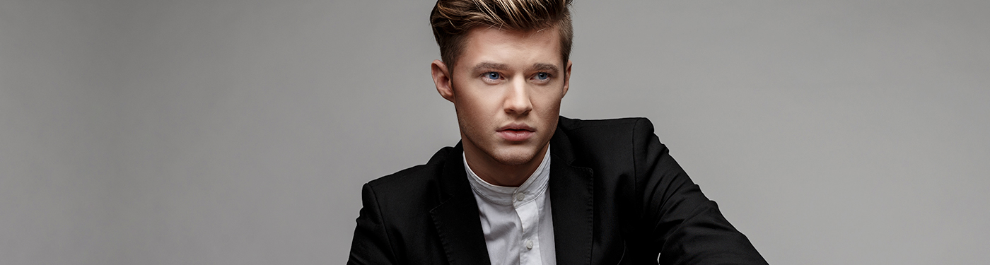 A man with a textured quiff and a dark blazer