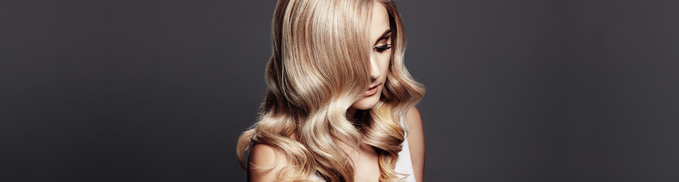 Long blonde waves styled with a soft bend